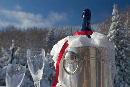 Glasses and bottle of champagne in snowの写真素材