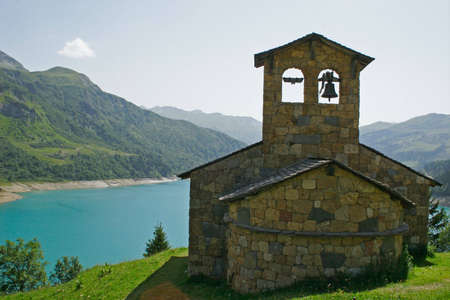Old church at the edge of a lake in mountainの写真素材