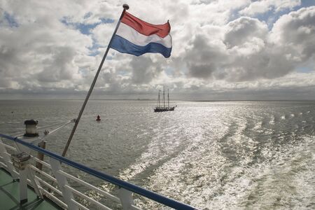 Wadden Sea with Dutch flag as seen from the ferryの写真素材