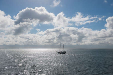 Sun over the Wadden Sea with sailing boatの写真素材