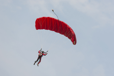 Parachutist floating to a square-shaped parachuteの写真素材