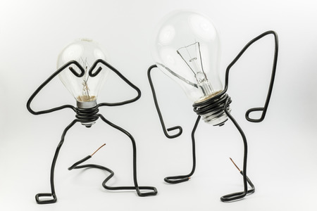 Two emotional fantasy figures of transparant light bulbs and black electrical wires