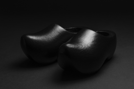 Two traditional Dutch black wooden shoes in a low key recordingの写真素材
