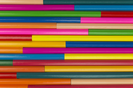 Collection of coloured pencils in a horizontal line pattern as background picture