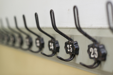 Old fashioned authentic coat hooks in a row on a wall of a dutch schoolの写真素材