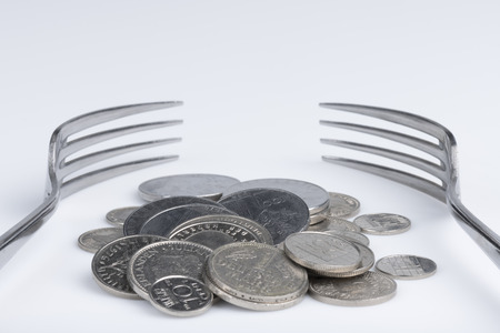 Conceptual representation of financial greed by two forks and coinsの写真素材