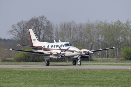 Twin-engined propeller business plane during landing at a small airport