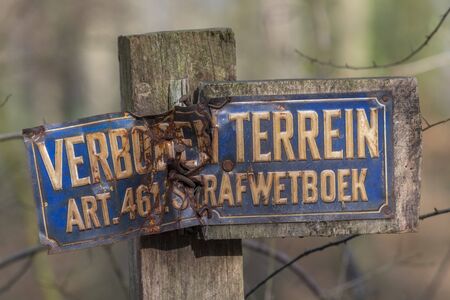 Old weathered sign forbidden entry in Dutch language on a poleの写真素材