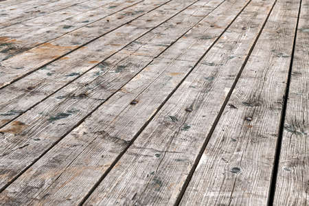 Background photo of weathered gray wooden reclining planks shown full screenの写真素材