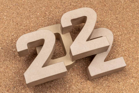 The year twenty twenty-two in large cardboard numbers on a cork background
