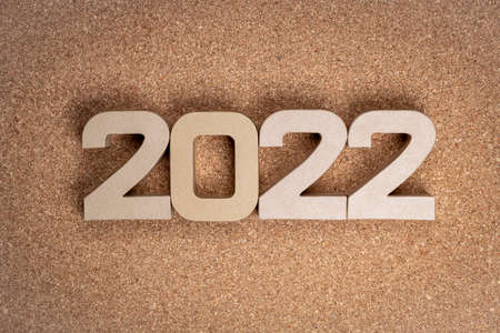 The year twenty twenty-two in large cardboard numbers on a cork backgroundの写真素材