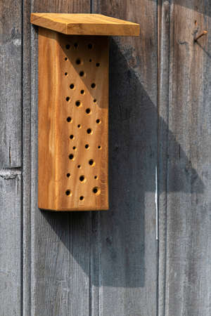 Insect hotel made of residual wood, consisting of a block of residual wood with pre-drilled holes,...