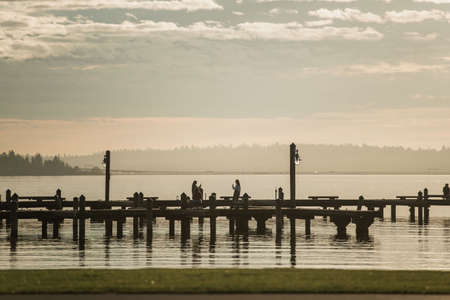 Sunset Seattle Washington over Lake Washington. Dog and People Silhouettes on the Dock.のeditorial素材