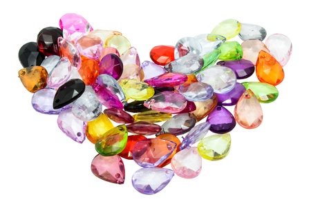 Colorful plastic beads isolated on white background shape of heart の写真素材