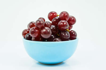 Fresh Grapes in a Blue Ceramic Bowl on white background の写真素材