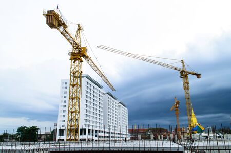 Construction site with crane near building on Cloudy storm background 