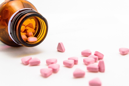 Pills pouring out of  the brown bottle  Isolated on a white background の写真素材