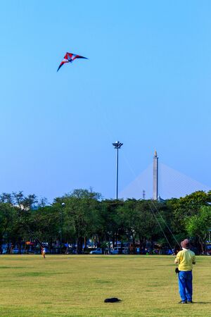 Young man flying a kite at Royal Plaza Park  Sanam Luang Park  in Bangkok のeditorial素材