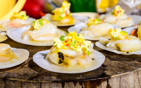 Raw Scallops topped with butter, garlic and parsley on Chopping wood の写真素材
