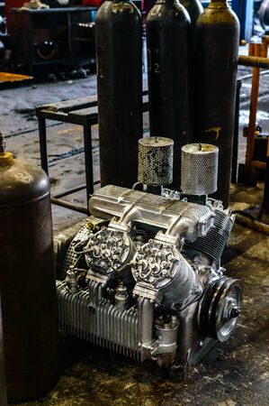 Engine on the floor with gas tank in garage の写真素材