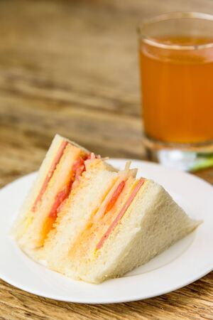 Ham and Cheese Sandwich with Orange Juice on Wood Table.の写真素材