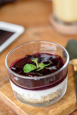 Blueberry Cheese Cake in the glass bowl on wood plate.の写真素材