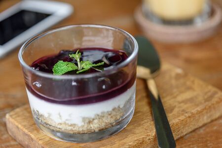 Blueberry Cheese Cake in the glass bowl on wood plate.