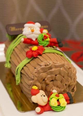 Traditional Christmas Yule Log cake decorated with santa bear and fiower mazipan の写真素材