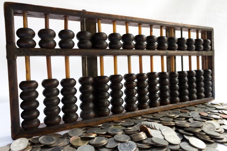 Abacus and coin on white backgroundの写真素材