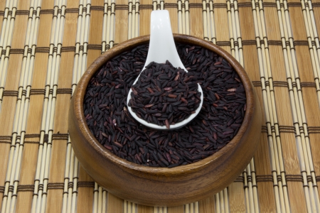 Black rice in wood blow and ceramic spoon with tablematの写真素材