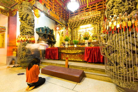 Samutprakarn,Thailand - March 1,2015 : Woman pray and light incense at a chinese temple.