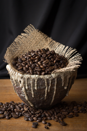 coffee bean in ceramic cup on wood tableの写真素材