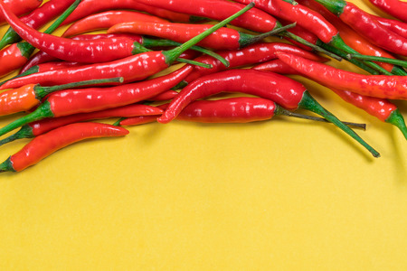 Red chili peppers on yellow backgroundの写真素材
