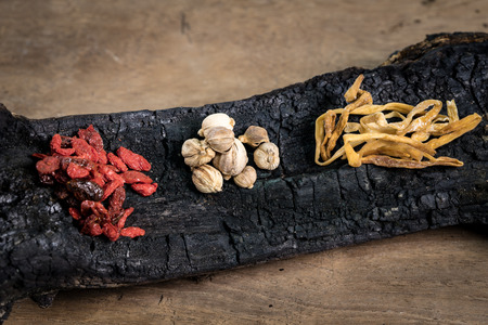 Spices and herbs on burnt woodの写真素材