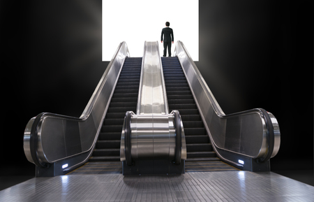 escalator lead businessman to a lightの写真素材