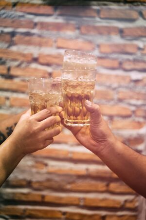 Glasses of beer in human hands during a toast