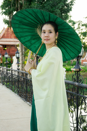Portrait of woman dressing in Thai traditional costume using an umbellaの写真素材