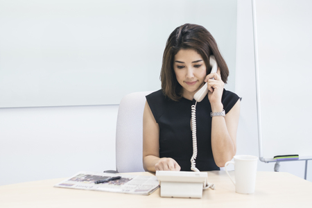 Business woman using phone in workplace officeの写真素材