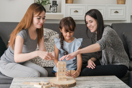 Parents with kid playing toy at homeの写真素材