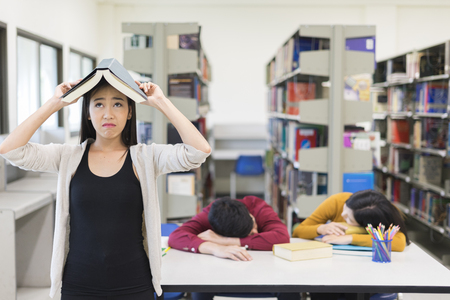 Young tired students rest in University libraryの写真素材