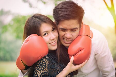 Couple in love.Young man and girl with red boxing gloves in pubic park.の写真素材