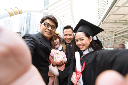 Graduating Students holding their diploma and take selfie