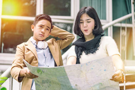 teenage couple holding map in hands and looking for their way.の写真素材