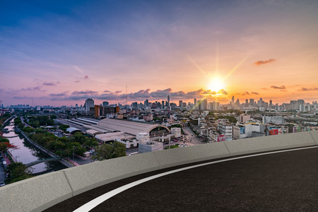 empty asphalt road with city scape in sunset backgroundの写真素材
