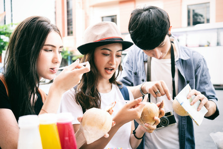 Group of young tourist drinking fresh fruit juice on a street at china town bangkok,Thailandの写真素材