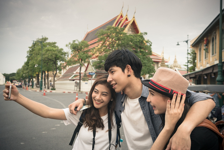 Group of tourist are selfies themself at the street in front of the temple in Thailandの写真素材
