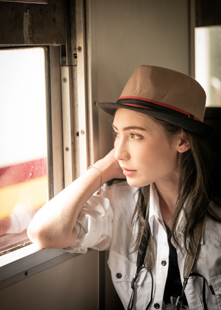 Young woman traveling by train looking out the windowの写真素材