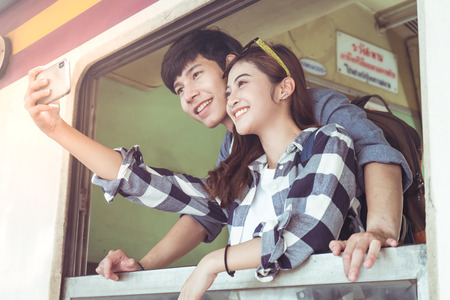 Tourists taking selfie with smart phone in train staionの写真素材