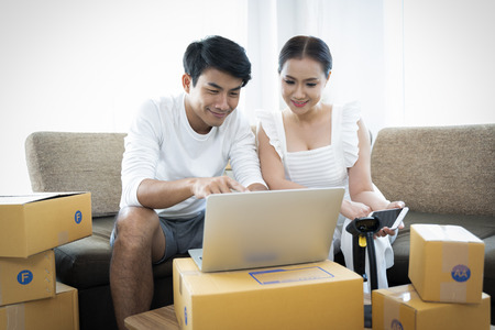 Happy couple success in their owner small business online with package boxの写真素材