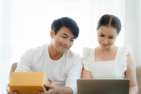 Young couple working with their small business at home office togetherの写真素材
